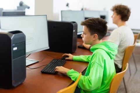 Preteen boy learning basics of programming in computer college Foto stock