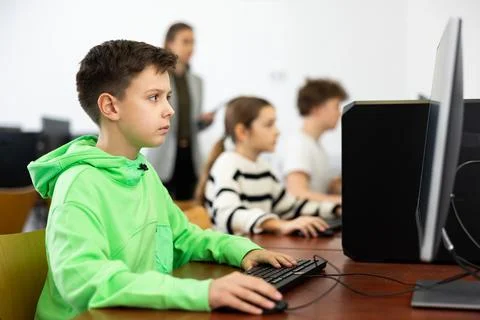Preteen boy learning basics of programming in computer college 库存照片