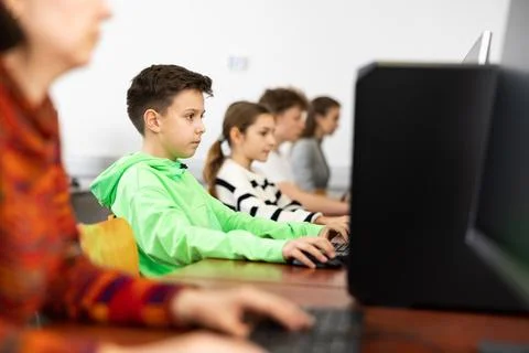 Preteen boy learning basics of programming in computer college Stock Photos