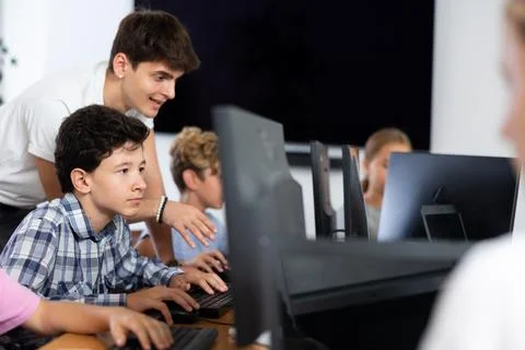 Preteen boy learning computer programs with teacher in training room 스톡 사진