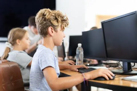 Preteen boy working with computer programs in training room Fotos de archivo