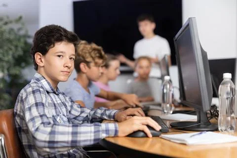 Preteen boy working with computer programs in training room 库存照片