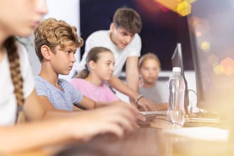 Preteen boy working with computer programs in training room Foto stock