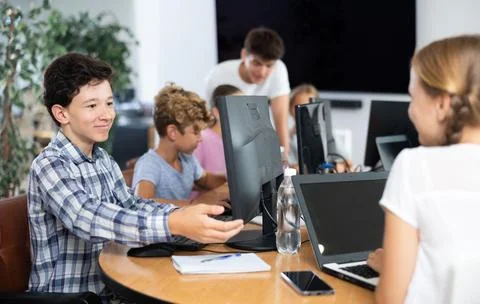Preteen boy working with computer programs in training room Foto stock