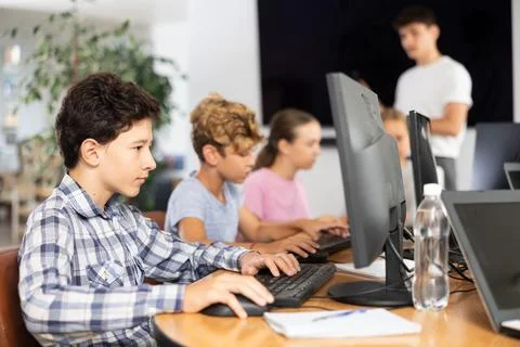 Preteen boy working with computer programs in training room Stock-Fotos