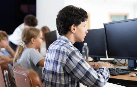 Preteen boy working with computer programs in training room Fotos de archivo