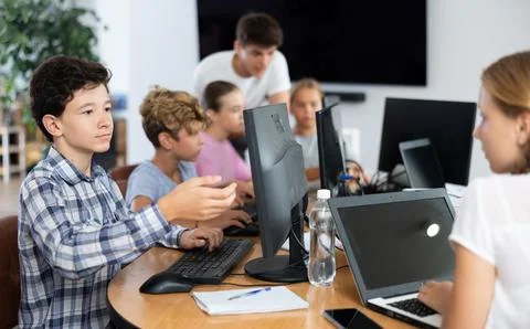 Preteen boy working with computer programs in training room Stock Photos