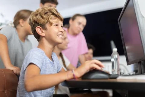 Preteen boy working with computer programs in training room Stock Photos