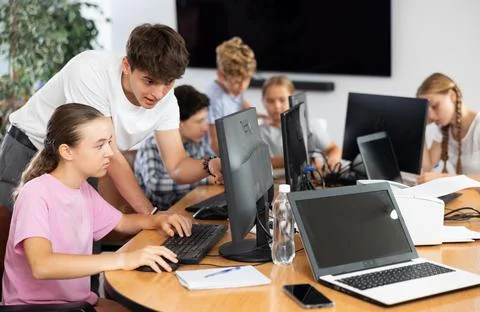 Preteen girl learning computer programs with teacher in training room 스톡 사진