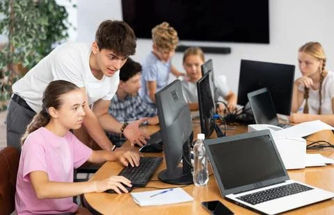 Preteen girl learning computer programs with teacher in training room 스톡 사진