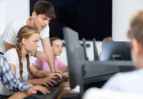 Preteen girl learning computer programs with teacher in training room 스톡 사진