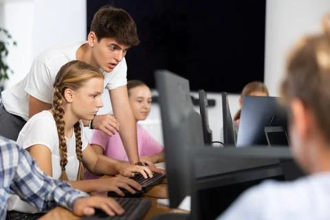 Preteen girl learning computer programs with teacher in training room Stock Photos