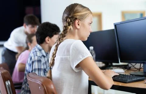 Preteen girl working with computer programs in training room Foto stock