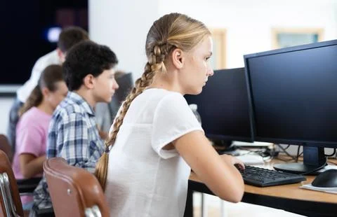 Preteen girl working with computer programs in training room Stock-Fotos
