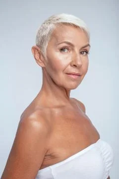 Pretty aged lady posing with her side to the camera Foto stock