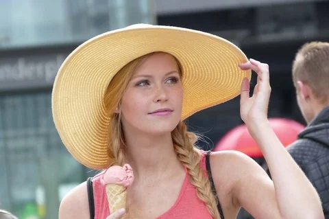 Pretty and young girl wearing a large hat and eating an ice cream Stock Footage