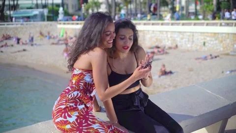 Pretty Arab / middle eastern girls looking at smartphone and laughing Stock Footage 78366514
