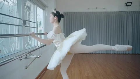 Pretty asian ballet dancer hang on to practicing on the barre. Stock Footage 280938564