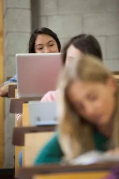 Pretty asian student using her laptop in a lecture hall Stock Photos