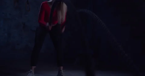 Pretty Athletic Female Actively in a Gym Exercises with Battle Ropes During Her Stock Footage 149242545