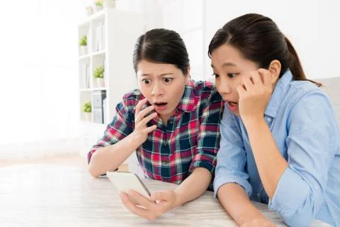 Pretty beautiful sisters using mobile cell phone Stockfoto's
