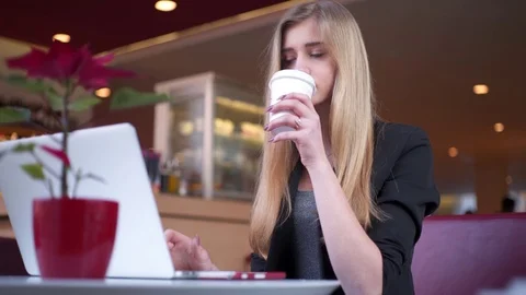 Pretty blonde in the black jacket is sitting in the cafe shop Stock Footage 74081149