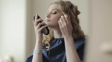 A pretty blonde makes herself makeup Stock Footage 49957333