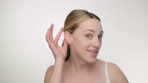 Pretty blonde model raises eyebrows with funny expression, straightens hair 스톡 동영상 193798786