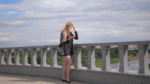 Pretty Blonde Pensive Is Looking At Cellphone, Touching Screen, In Full Growth Video stock 79390500