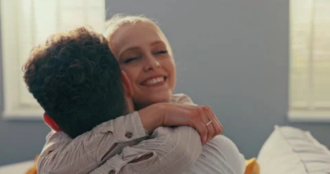 A pretty blonde sits on the couch next to her fianc , hugs him longingly, throws Stock-Footage 161749549