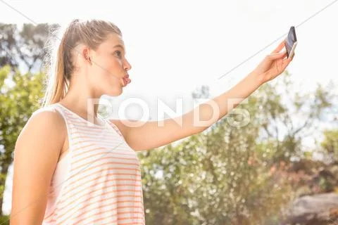 Pretty blonde taking selfie with outstretched tongue Stock Photos