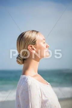 Pretty blonde woman closing her eyes facing the sun Stock Photos