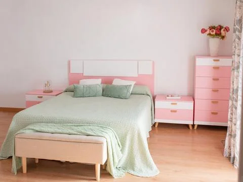 Pretty boho styled bedroom with fresh cut flowers and pink sheepskin Stock Photos