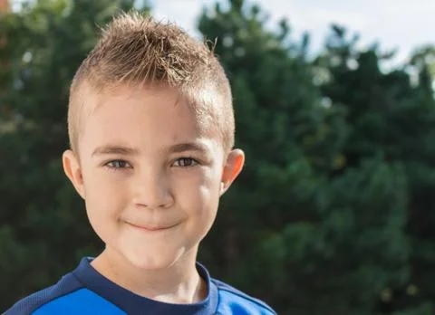 Pretty boy looking at camera outdoors shot Stock Photos