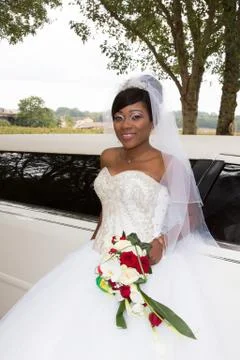Pretty bride african american woman in weddin day with white limousine car Stock Photos
