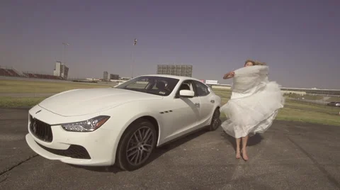 Pretty bride dances in front of her new car 動画素材 61057344