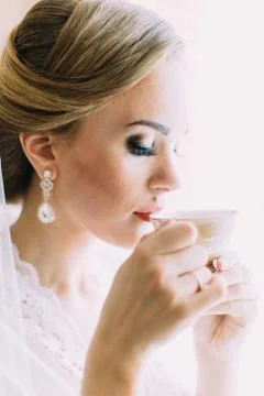 Pretty bride is drinking tea. Side portrait. Foto stock