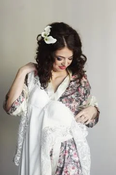 Pretty bride smiles while trying on her dress Stock Photos