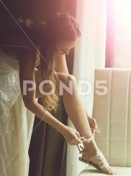 Pretty bride wears lace garter on sexi leg Stock Photos