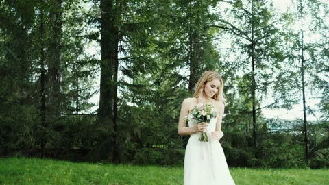 Pretty bride with wedding bouquet looking at camera and smiling. Stock Footage 85498105