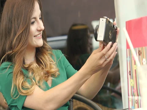 Pretty brunette doing selfies on old vintage camera, steadycam shot Stock Footage