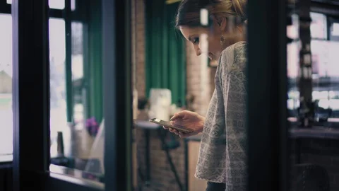 Pretty brunette is using apps on smartphone, smiling and having a phone call Stock Footage 86698535