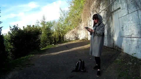 Pretty brunette using digital tablet at the park 2 Stock Footage 89863919