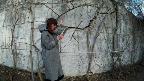 Pretty brunette using digital tablet at the park 4 Stock Footage 89864677