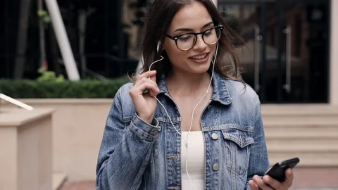 Pretty Brunette Woman Walking in the Street. Singing while Listening to Music Stock Footage