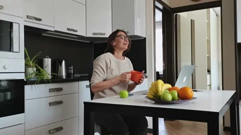 Pretty brunette working in the kitchen in front of laptop. Stock Footage 164709672