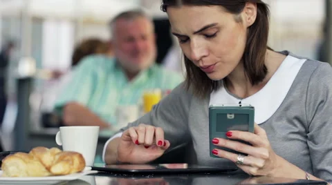 Pretty businesswoman comparing data on tablet computer and smartphone in cafe HD Stock Footage 47102978