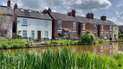 Pretty canal waterside former workers cottages blue sky clouds Stock Footage 276415941