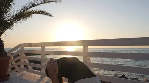 Pretty caucasian woman doing yoga asana in the nature on a wooden bridge overl Stock Footage