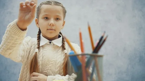 Pretty child coosing proper colored pencil, slightly hesitating, then thinking Video stock 113070653